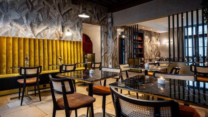 Ein Esszimmer mit vielen Tischen und Stühlen