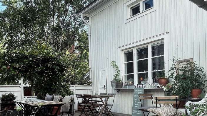 Ein weißes Haus mit einem Tisch und Stühlen davor