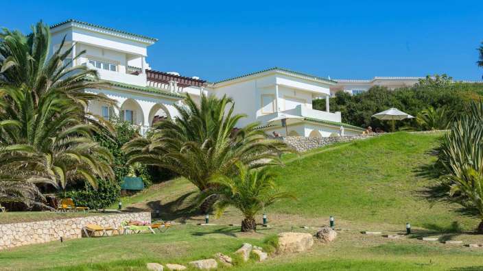 Ein großes weißes Haus mit Palmen davor