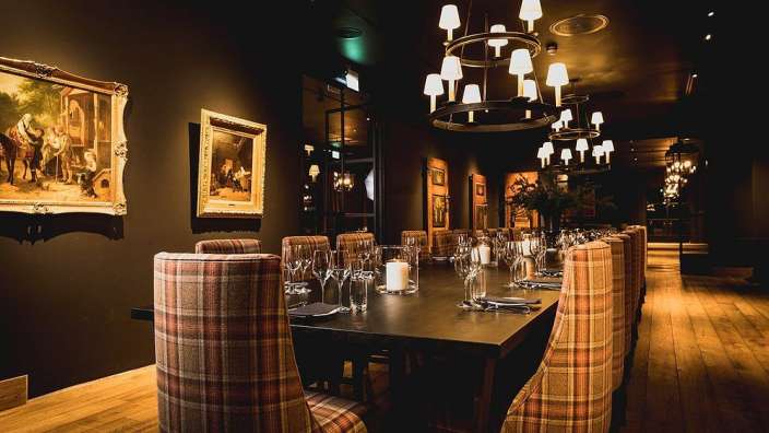 Ein Esszimmer mit einem Tisch und Stühlen und einem Gemälde an der Wand