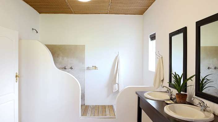 Ein Badezimmer mit zwei Waschbecken und zwei Spiegeln