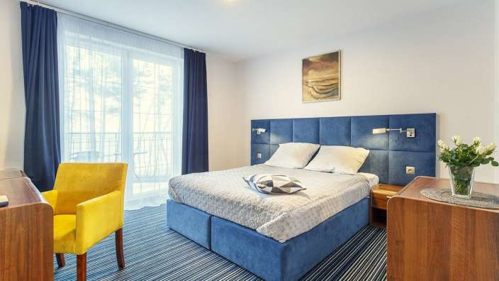 Ein Hotelzimmer mit einem großen Bett und einem gelben Stuhl