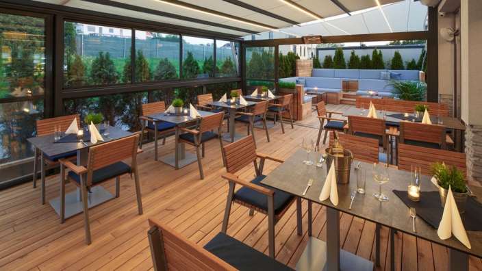 Tische und Stühle in einem Restaurant mit einem Schild darüber