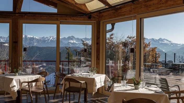 Tische und Stühle in einem Restaurant mit Blick auf die Berge