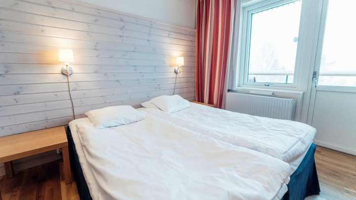 Ein Hotelzimmer mit zwei Betten und einem Fenster