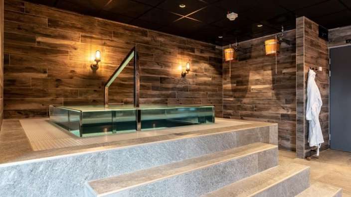 Eine Badewanne in einem Badezimmer mit Holzwänden