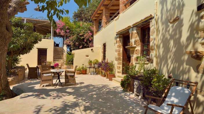 Eine Terrasse mit einem Tisch und Stühlen vor einem Gebäude