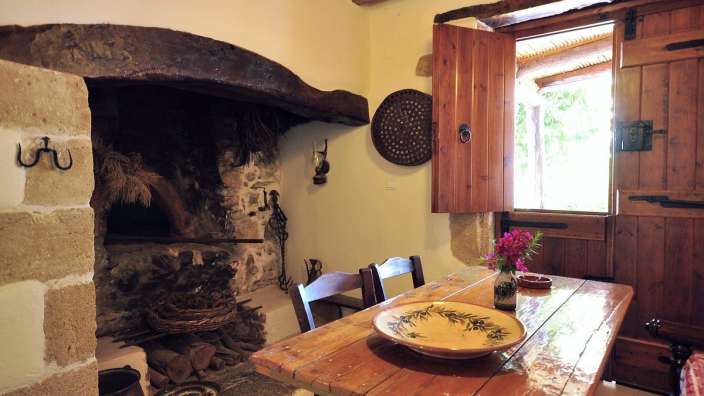 Ein Holztisch mit einem Teller auf einem Tisch neben einem Kamin