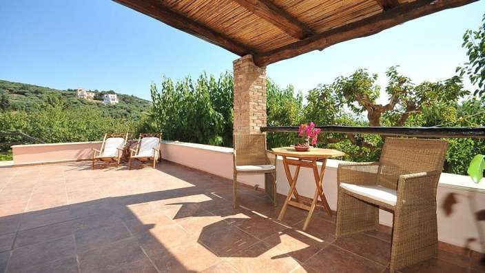 Ein Tisch und Stühle auf einem Balkon mit Blick auf die Berge