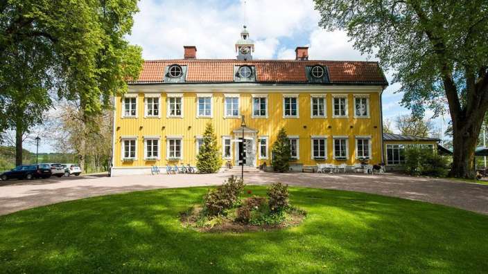 Ein großes gelbes Gebäude mit einem Uhrturm darauf