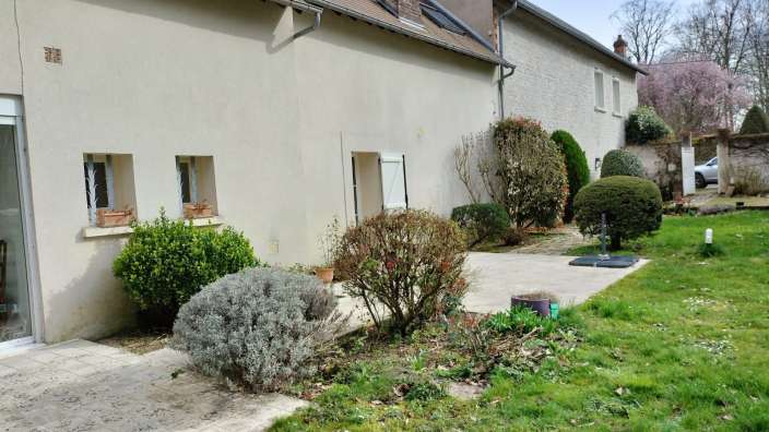 Ein Haus mit einer Terrasse und einem Garten davor