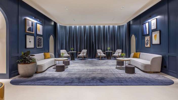 Ein Wohnzimmer mit blauen Wänden und weißen Möbeln