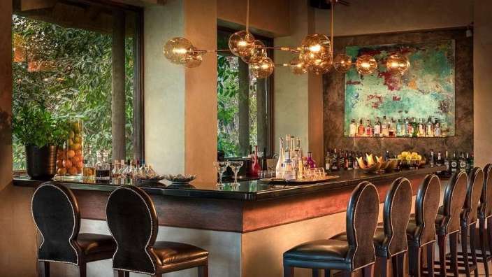 Eine Bar mit Stühlen und Flaschen an der Wand