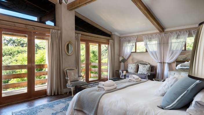 Ein Schlafzimmer mit einem Kingsize-Bett und vielen Fenstern