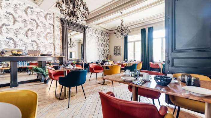 Ein Esszimmer mit bunten Stühlen und Tischen