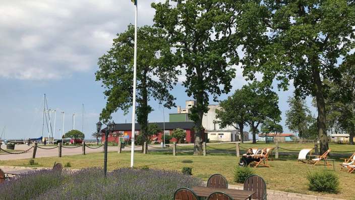 Ein Tisch und Stühle in einem Park mit einer Flagge im Hintergrund