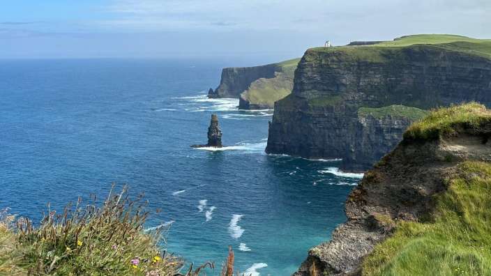 Eine Klippe über dem Ozean mit einem Turm darauf