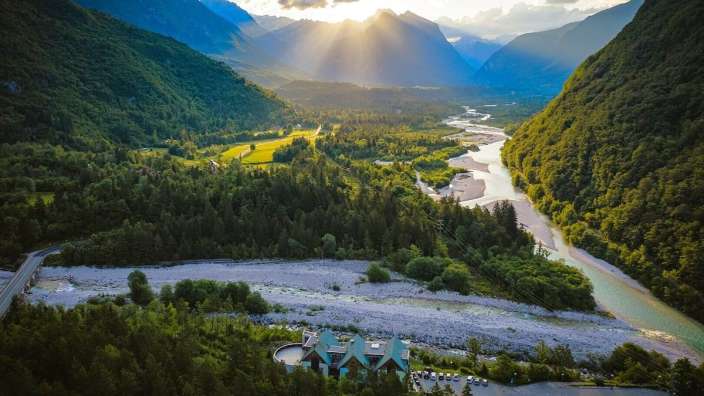Die Sonne scheint durch die Wolken über einen Fluss