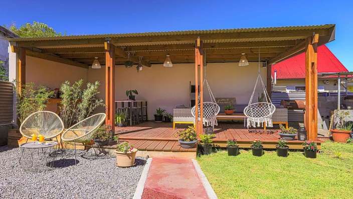 Ein Holzdeck mit Schaukelstühlen und einem Willkommensschild