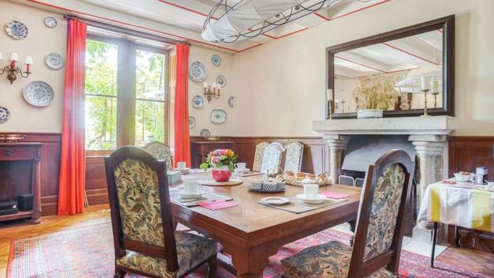 Ein Esszimmer mit einem Tisch und Stühlen und einem Kamin