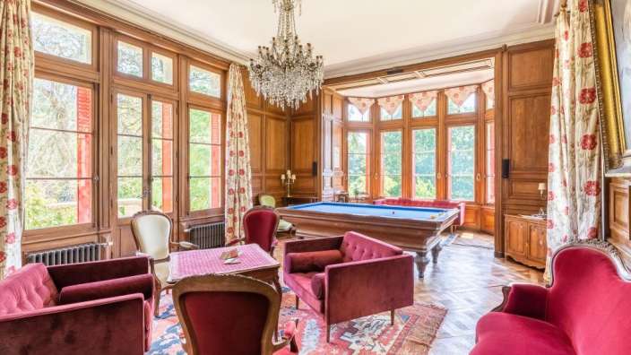 Ein Wohnzimmer mit Pooltisch und roten Möbeln