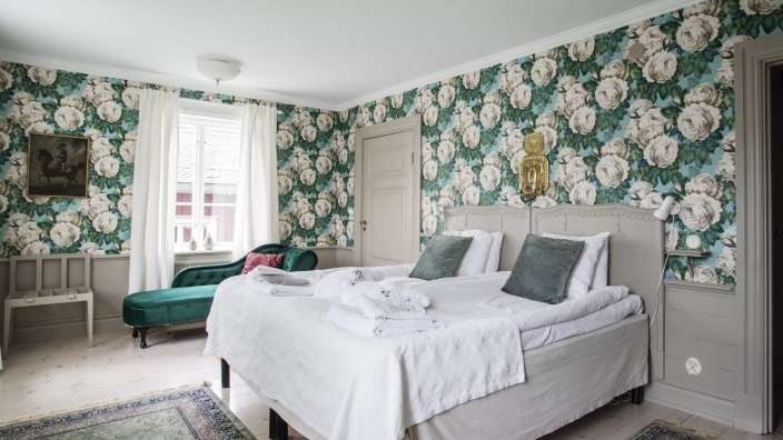 Ein Schlafzimmer mit Blumentapeten und einem Bett