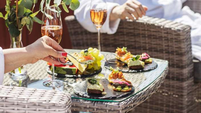 Eine Frau hält einen Löffel in der Hand und hält ein Glas Champagner