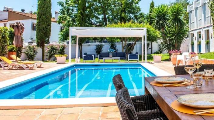 Ein Tisch mit Tellern und Gläsern in der Nähe eines Swimmingpools