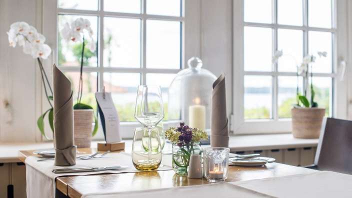 Ein Tisch mit Gläsern und Kerzen steht vor einem Fenster