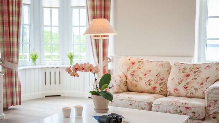 Ein Wohnzimmer mit einem Blumensofa und einem Couchtisch