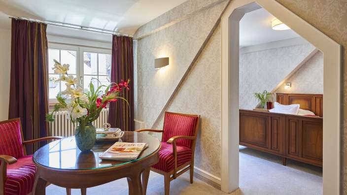 Ein Zimmer mit einem Tisch und Stühlen und einem Bett