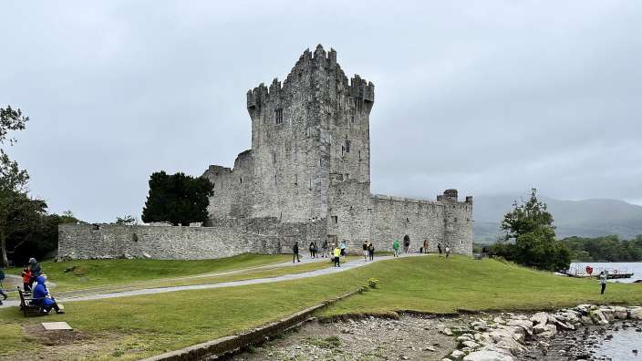 Eine Gruppe von Menschen steht vor einem großen Steinturm