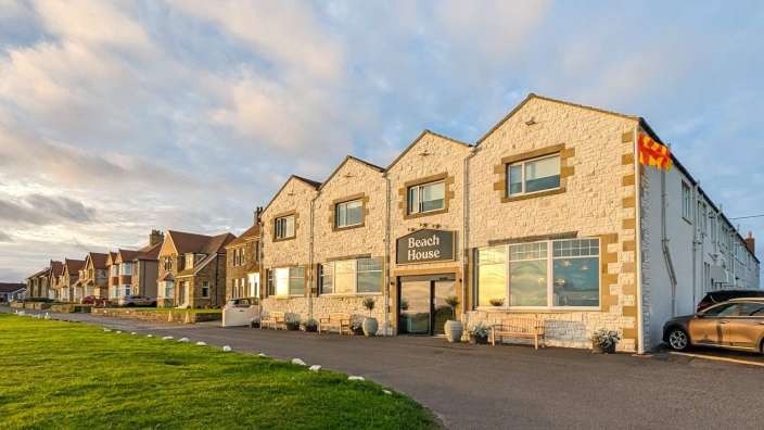 Ein großes weißes Gebäude mit der Aufschrift beach house darauf