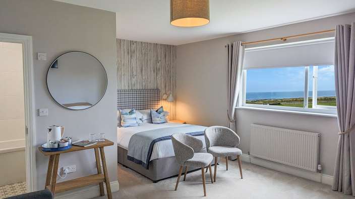 Ein Schlafzimmer mit einem Bett und zwei Stühlen