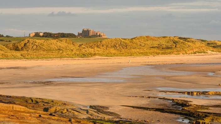 Ein Strand mit einem großen Schloss im Hintergrund