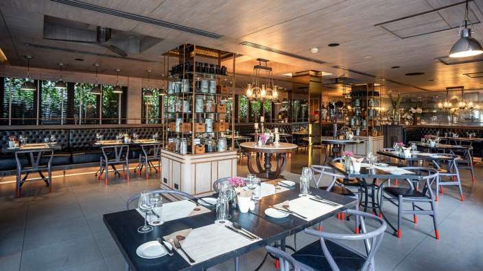 Ein Esszimmer mit vielen Tischen und Stühlen