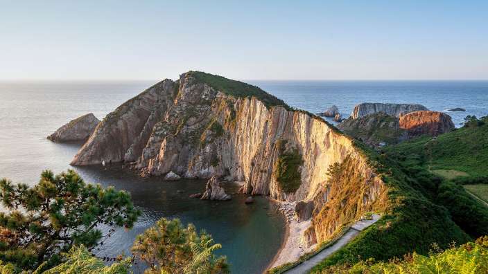 Blick auf den Silence Beach Eine Straße führt an einer Klippe ins Meer