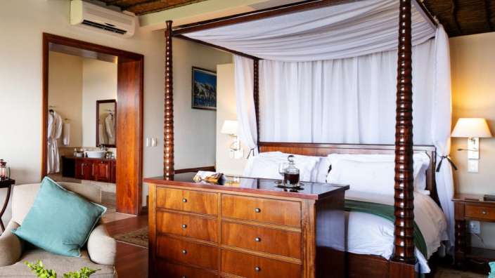 Ein Schlafzimmer mit einem Himmelbett und einer Kommode