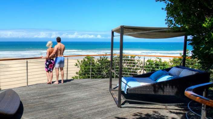 Ein Mann und eine Frau stehen auf einem Deck mit Blick auf den Ozean