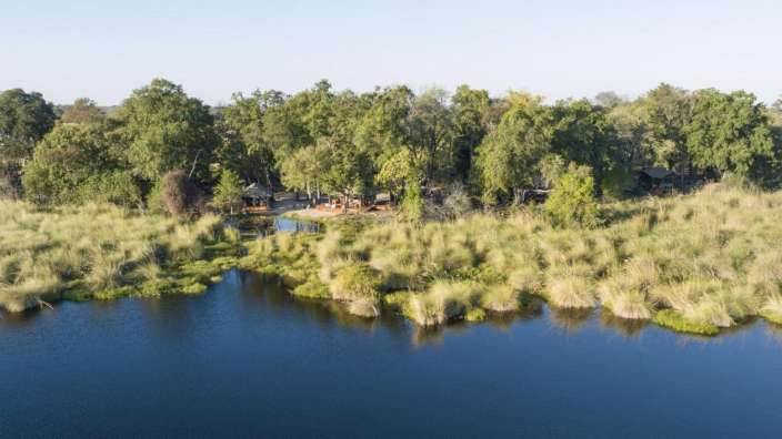 Ein großer See umgeben von Bäumen und Gras
