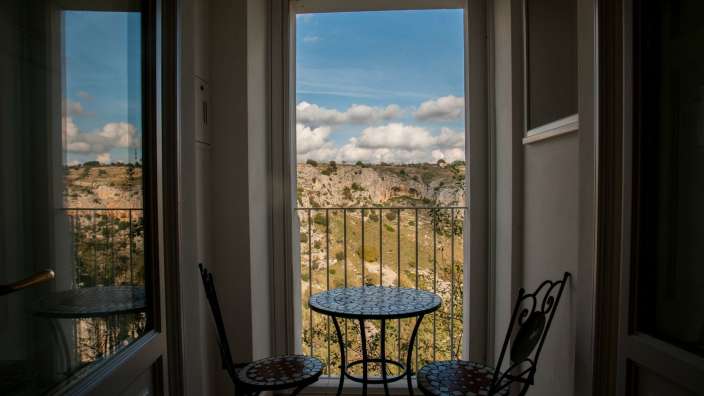Ein Tisch und Stühle auf einem Balkon mit Blick auf die Landschaft