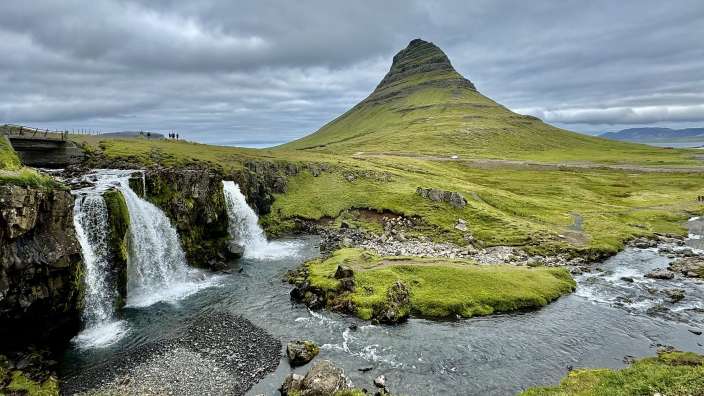 Ein Wasserfall mit einem Berg im Hintergrund
