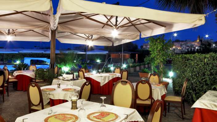 Tische und Stühle in einem Restaurant mit Regenschirmen