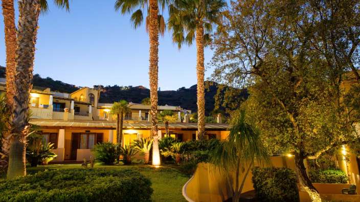 Eine Gruppe von Palmen steht vor einem Gebäude