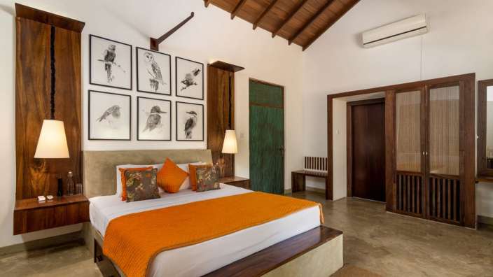 Ein Schlafzimmer mit einem Bett und Bildern von Vögeln an der Wand