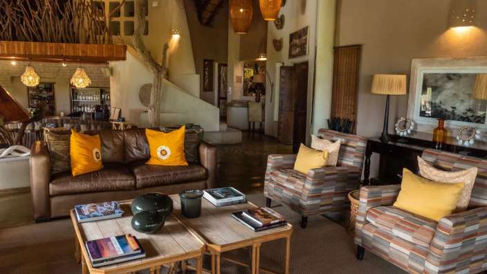 Ein Wohnzimmer mit einem braunen Ledersofa und gelben Kissen