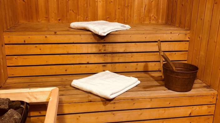 Eine Holzsauna mit zwei Handtüchern und einem Eimer