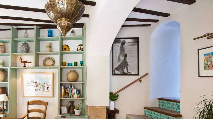 Ein Wohnzimmer mit Bücherregalen und Bildern an der Wand