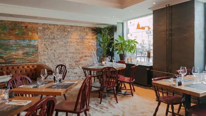 Tische und Stühle in einem Restaurant mit einem Gemälde an der Wand