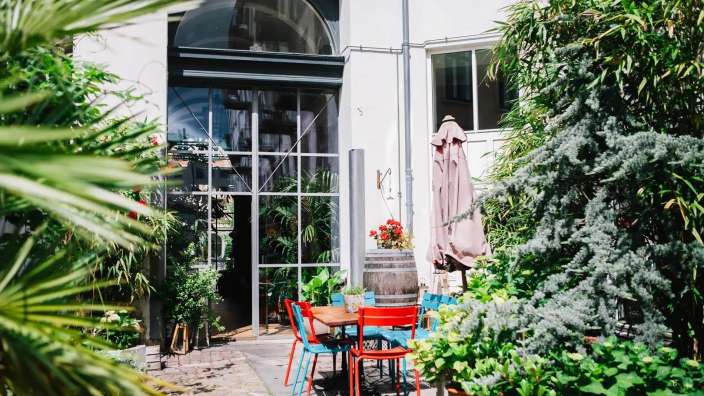 Ein Tisch und Stühle stehen vor einem Gebäude mit der Nummer 5 darauf